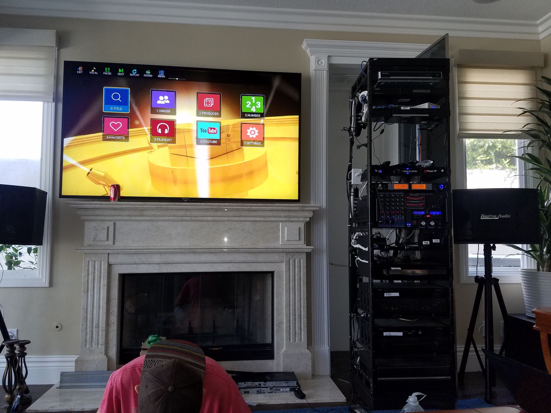 Wall-mounted TV beside a fireplace with the equipment rack alongside